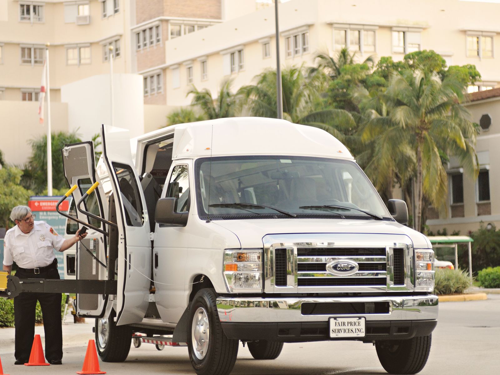 A uniformed driver operating the wheelchair lift on a clean, accessible fleet van.